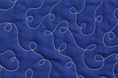 a blue quilt with white stitching on it and an image of the back side