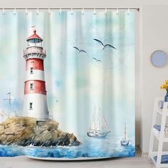 a shower curtain with a lighthouse and sailboat on the water in front of it