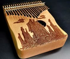 a wooden instrument with an intricate design on the front and sides, sitting on a black surface