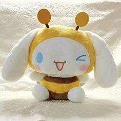 a stuffed animal that is sitting on a white sheet with the eyes closed and ears wide open