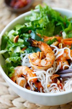 a white bowl filled with noodles and shrimp