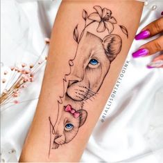 a woman's arm with a lion and cub tattoo on the left side of her leg