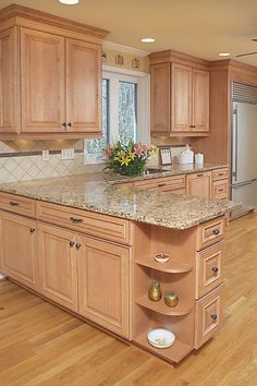 a large kitchen with wooden cabinets and marble counter tops, along with hardwood flooring