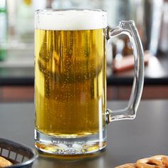 two mugs of beer sitting on top of a wooden table