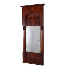 an old wooden grandfather clock with mirror on it's face and wood trimmings