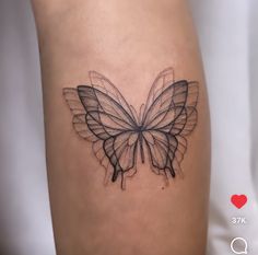 a black and white butterfly tattoo on the right side of the thigh, it is drawn with lines