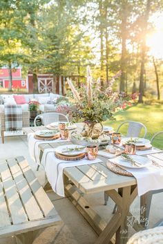 an outdoor table set with plates and place settings