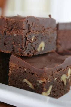 some brownies are stacked on top of each other and ready to be cut into pieces