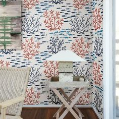 a chair and table in front of a wallpapered room with corals on it