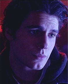 a close up of a person wearing a hoodie and looking at the camera with an intense look on his face