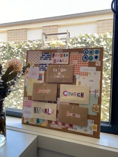 a vase with flowers in it sitting next to a bulletin board on a window sill