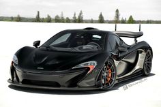 a black sports car parked on top of a snow covered field