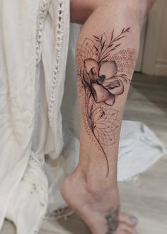 a woman's leg with a flower tattoo on it