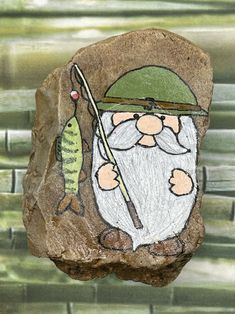 a rock with a drawing of a gnome holding a fishing rod and a fish on it