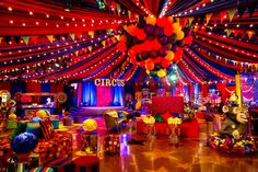 an elaborate party setup with balloons and streamers on the ceiling, decorated in bright colors