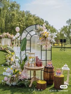 a table with vases, candles and flowers on it in front of a greenhouse