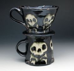 two black cups with skulls painted on them