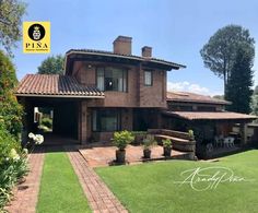 a large brick house sitting on top of a lush green field