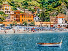 a boat floating on top of a body of water next to a beach covered in lots of people