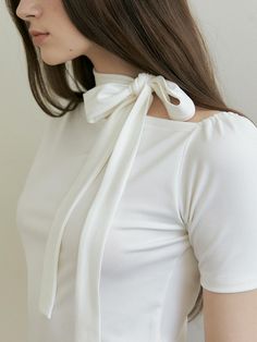 a woman wearing a white shirt and bow tie