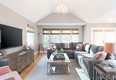 a living room filled with furniture and a large flat screen tv mounted on the wall