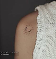 a woman with a small sun tattoo on her shoulder