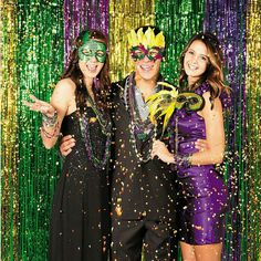 two women and a man standing in front of a photo booth with confetti