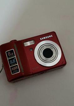 a red camera sitting on top of a white table