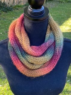 a multicolored knitted scarf on top of a mannequin headdress