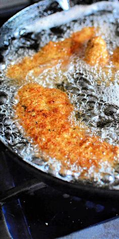 fried food being cooked in a frying pan on top of an electric stovetop