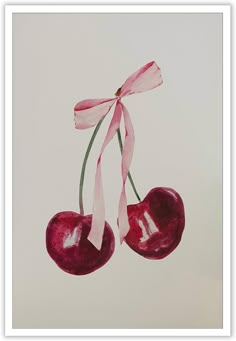 two cherries hanging from a pink ribbon