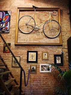 a brick wall with pictures and a bicycle on it