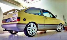 a yellow car parked in a garage next to a potted plant