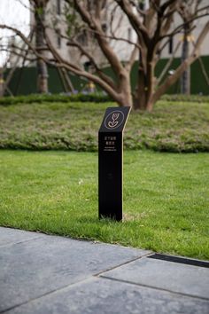 a black box sitting in the grass near a tree