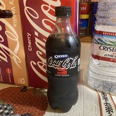 a bottle of coca - cola sitting on top of a table next to some water bottles