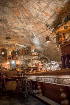 a room filled with lots of different types of items on shelves next to a stone wall