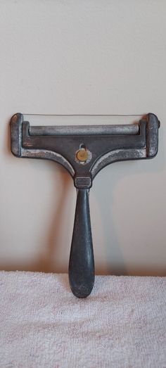 an old shaving razor sitting on top of a white towel next to a wall