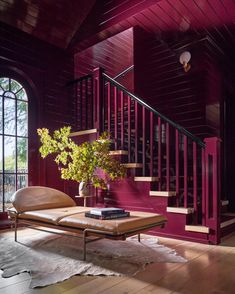 a living room with red walls and stairs