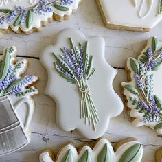 decorated cookies with lavenders and leaves on them next to cookie cutters that have been cut into the shape of flowers