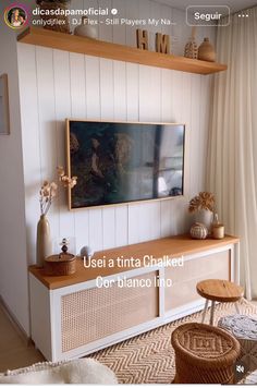 a living room filled with furniture and a painting hanging on the wall above it's entertainment center