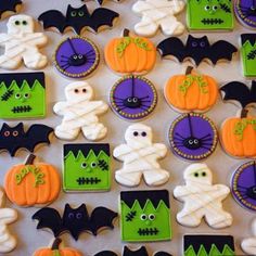 decorated cookies are arranged on a table with bats and jack - o'- lanterns