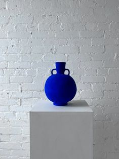 a blue vase sitting on top of a white block