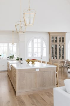 a large kitchen with an island in the middle and lots of windows on both sides