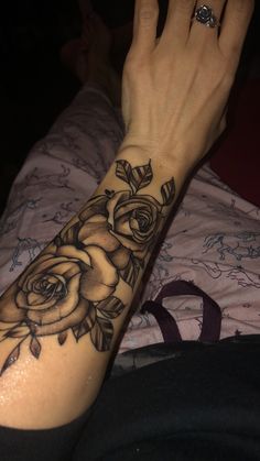 a woman's arm with a rose tattoo on it