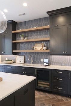 a kitchen with black cabinets and white counter tops