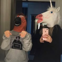 a person taking a selfie with a horse mask on and another person holding a cell phone