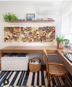 a room with a desk, chair and shelves filled with plants on top of it