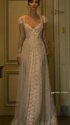 a woman in a white dress standing next to a door