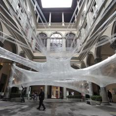 an art installation in the middle of a building with people walking around and looking at it