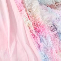 a blanket that has been dyed pink, blue and white with some feathers on it